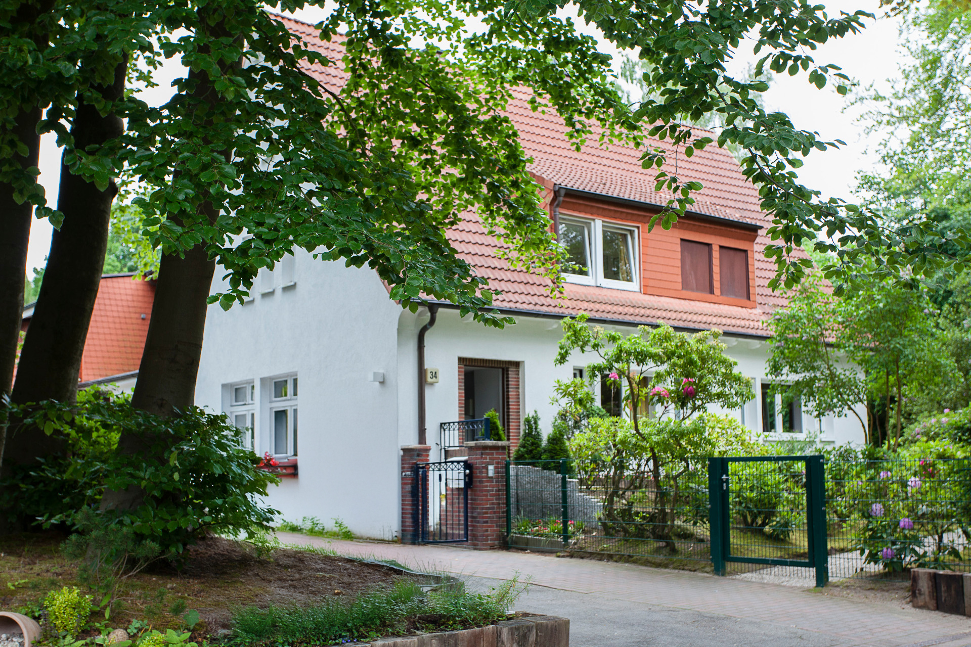 Das Haus Volksdorf und sein grünen Garten mit der großen Einfahrt.